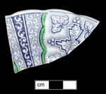 Saucer in printed under the glaze in purple, with green overglaze enamelled decoration.